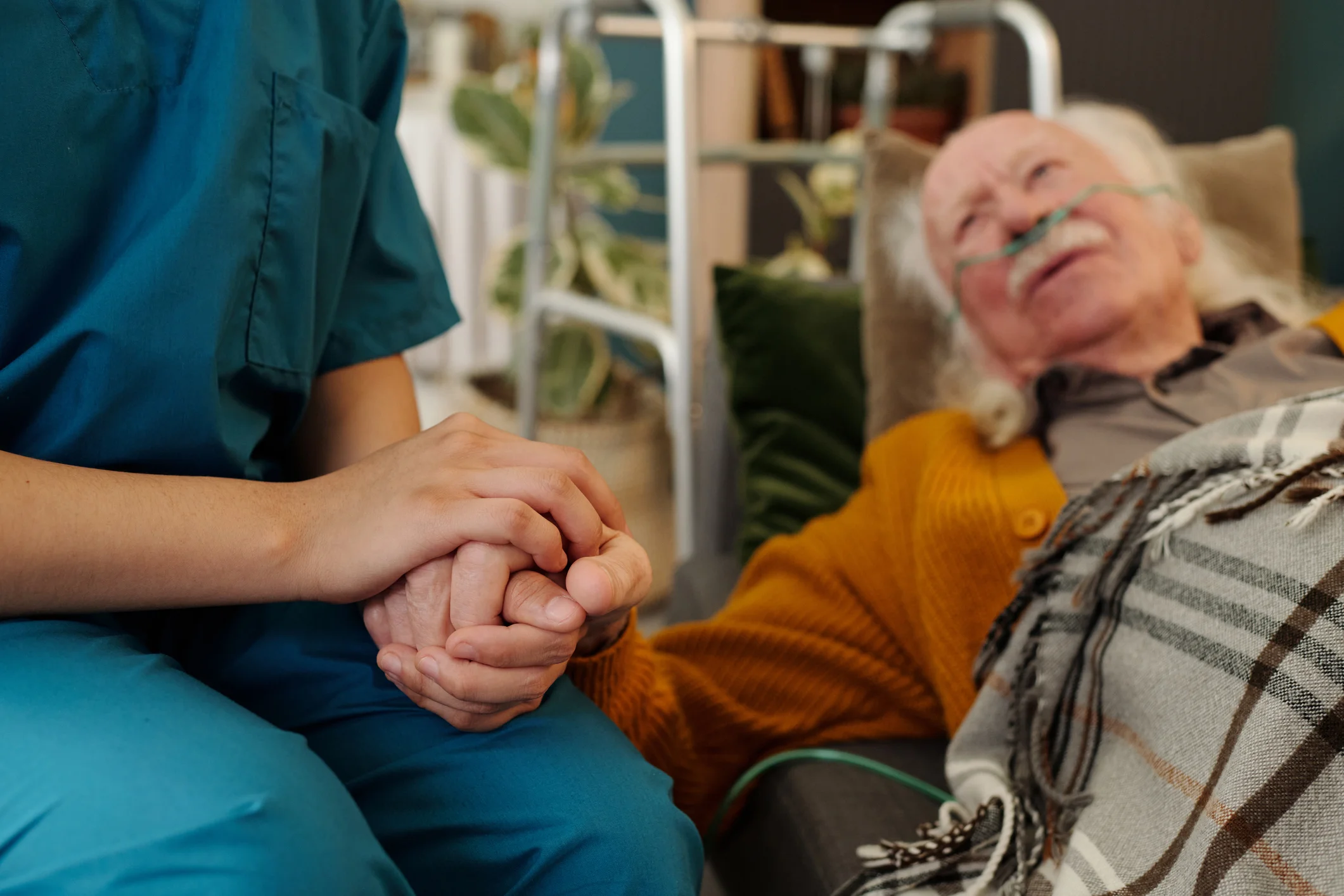 Hospice nurse holding the hand of an elderly patient providing compassionate end-of-life comfort care